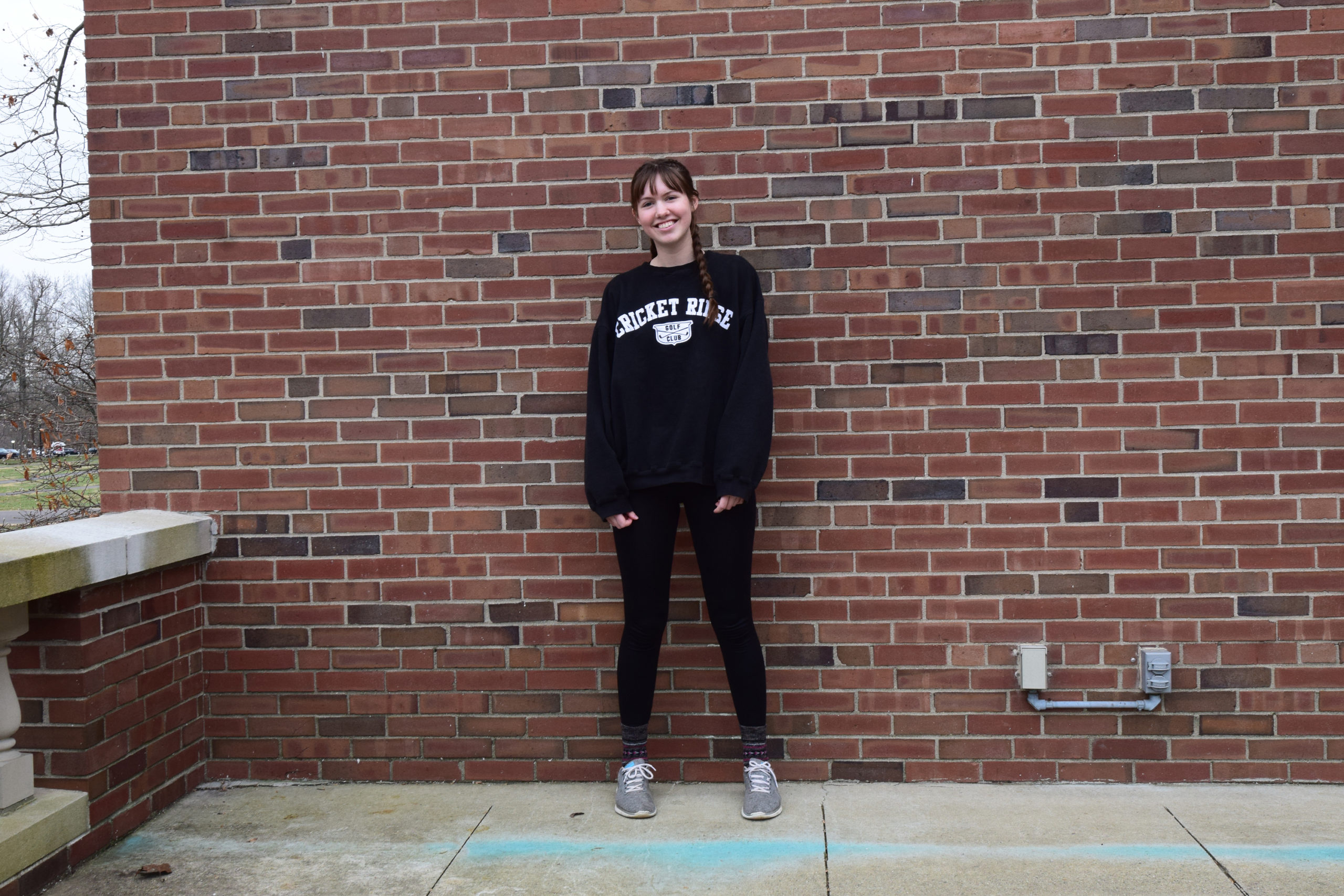 Rachel Jordan stands in front of a brick wall