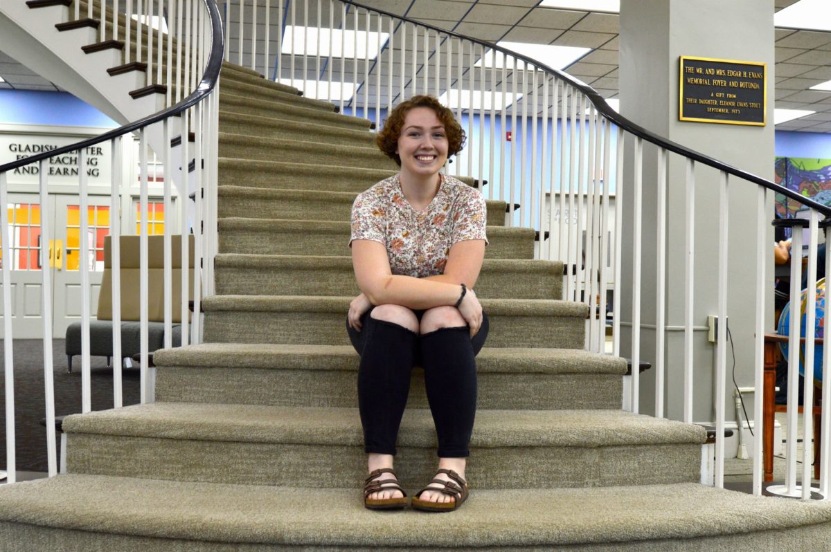Rosemary Kent sits on the stairs inside the Duggan Library