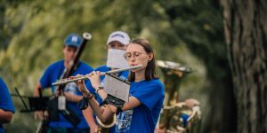 Student playing flute at outdoor concert