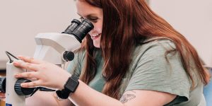 Student looking thru microscope in a lab