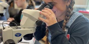 Student looking thru microscope in biology lab