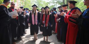 faculty applauding recent graduates
